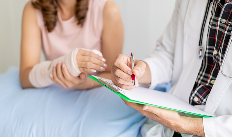 woman at the doctor with her arm in a cast